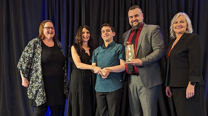 Brendan Ganton receives his award with Tylan and his family