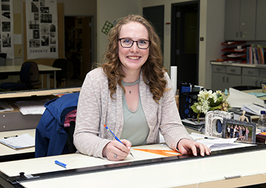 Courtney at her desk in one of ​Lakeland's interior design learning spaces.