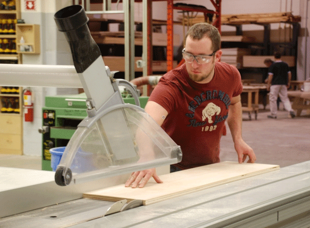 Student operating a saw in the workshop